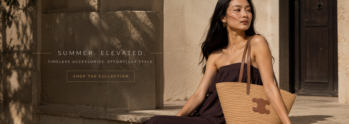 A woman sits outdoors against a stone wall wearing a dark strapless dress and holding a large woven straw tote bag with a brown logo patch. Text on the left reads 'SUMMER, ELEVATED.